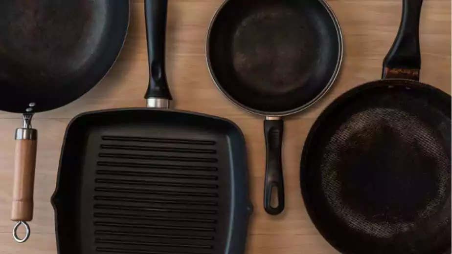 non stick frying pans on wooden background