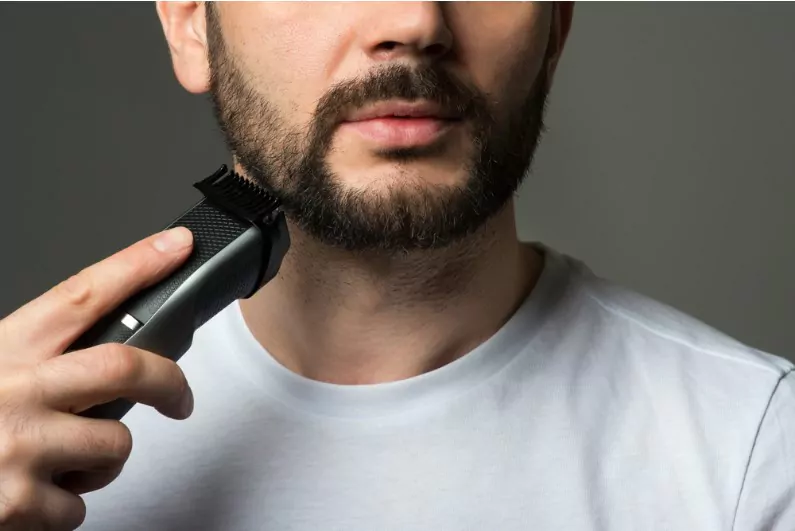 man trimming his beard with a trimmer