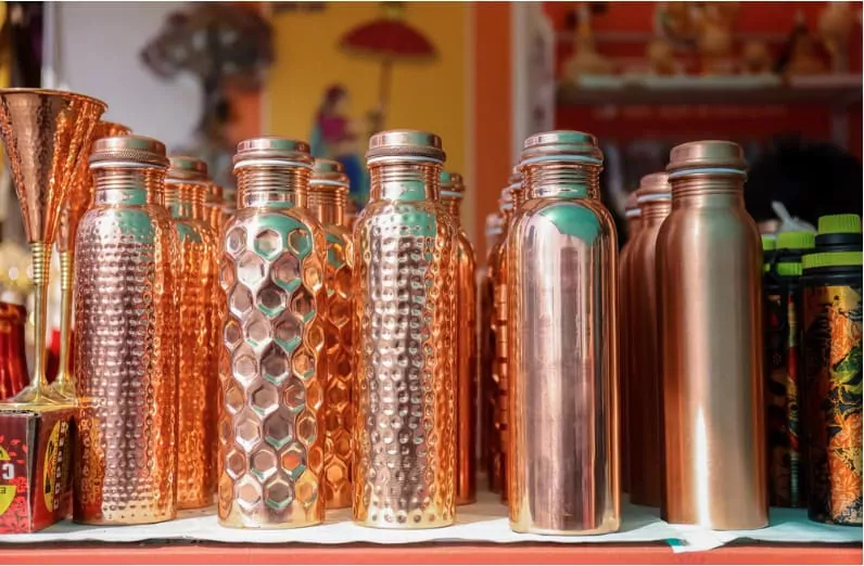 different copper bottles on display in a store