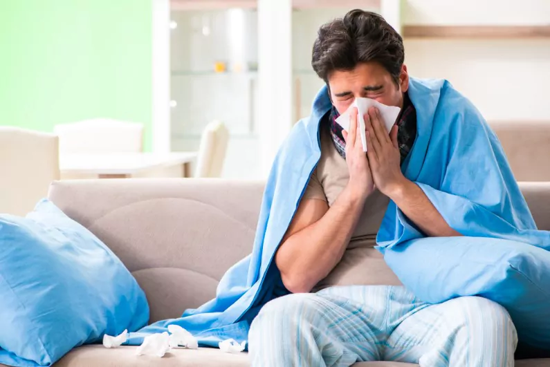 sick young man suffering from flu at home