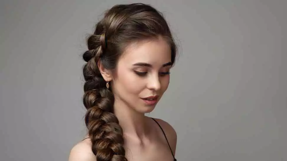 woman on a gray background with a braid hairstyle