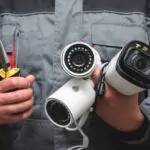 A technician holding cctv cameras from 3 different brands