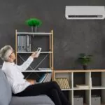 a senior man switching on ac in his workplace
