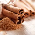 cinnamon sticks and meal close up on wooden table