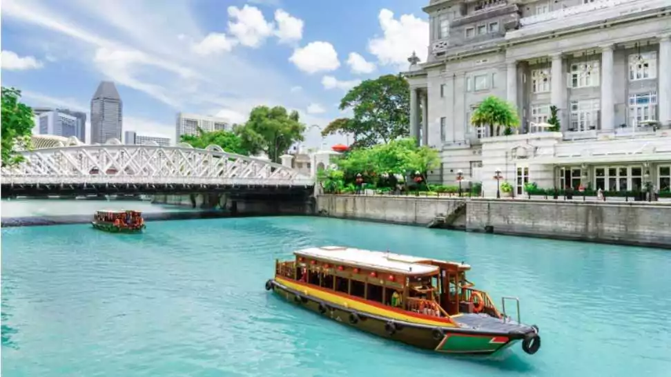 beautiful view of traditional tourist boats sailing along the singapore river