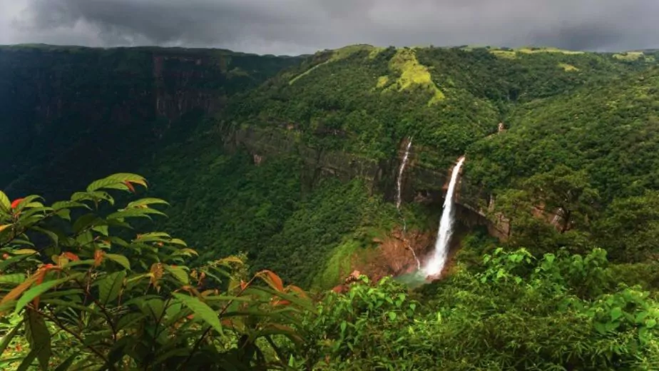 nohkalikai waterfalls flanked by deep gorge with forested slopes under overcast sky near shillong