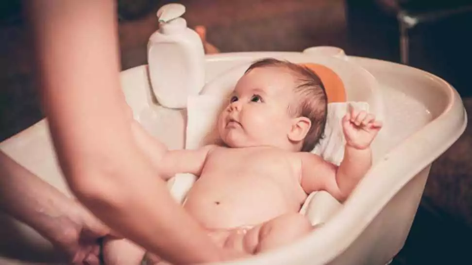 small baby first bathing on mothers hands