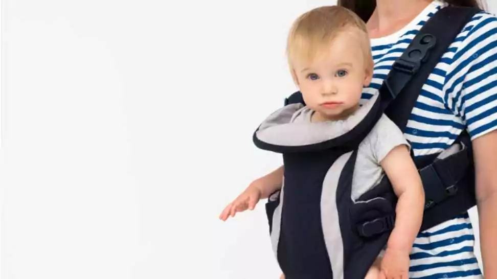 woman holding caucasian adorable blond child looking at camera in soft structured baby carrier backpack