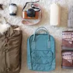 prepare for winter backpack coat boots hat sunglasses camera