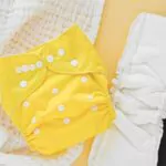 baby set of cloth diapers with diaper liners laying and muslin swaddle blanket
