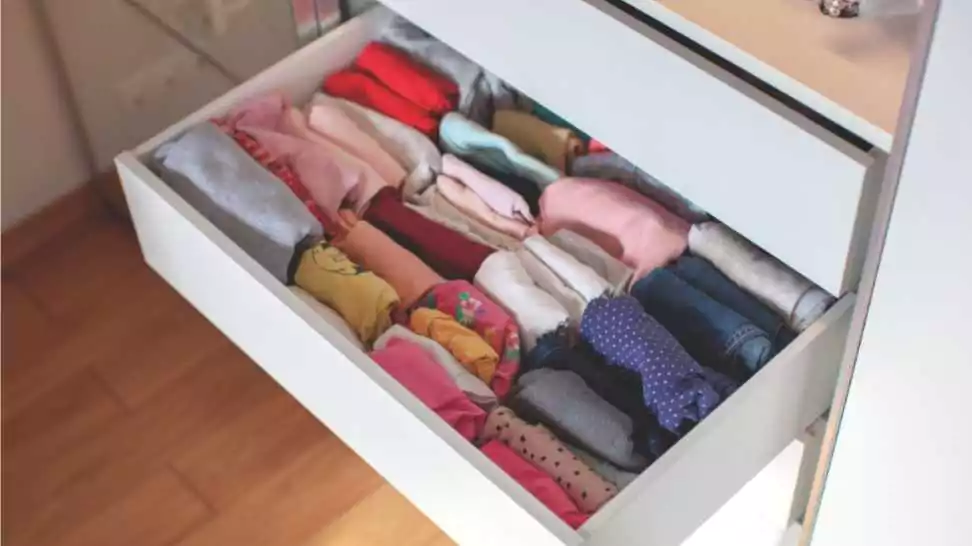 diapers and clothing folded for vertical storage in the linen drawer