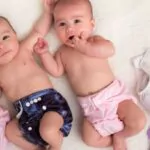 baby twins girls with cloth diapers on a bed