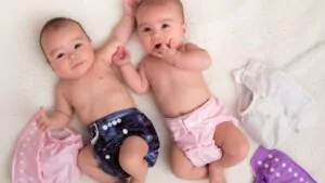 baby twins girls with cloth diapers on a bed