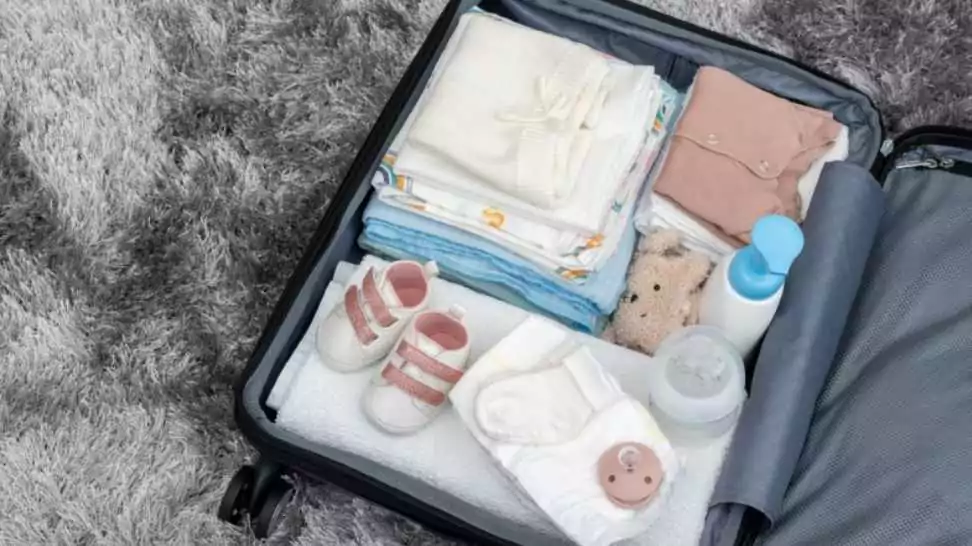 suitcase of baby clothes prepared for newborn birth