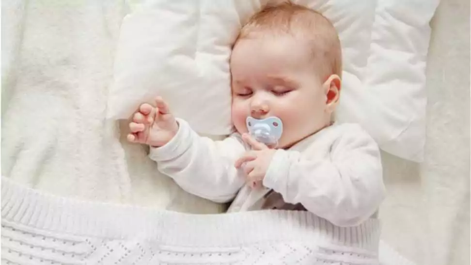 cute five month old baby sleeping in comfortable bed
