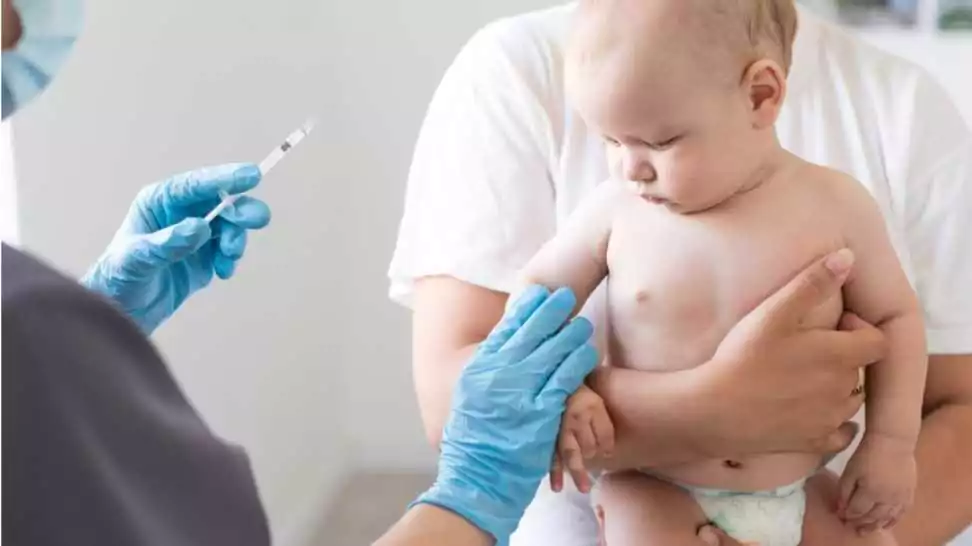 the doctor makes a baby vaccination on a white background