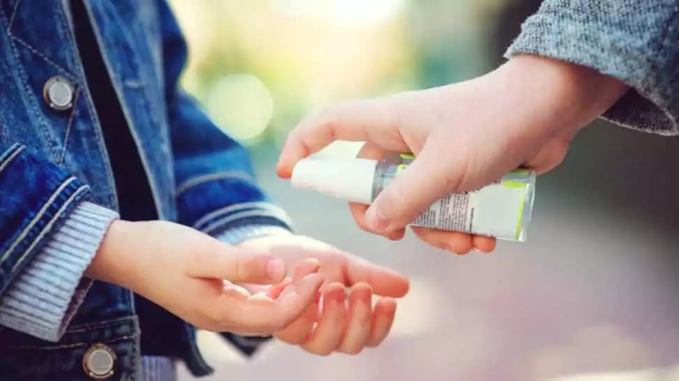 kids hands using sanitizer gel