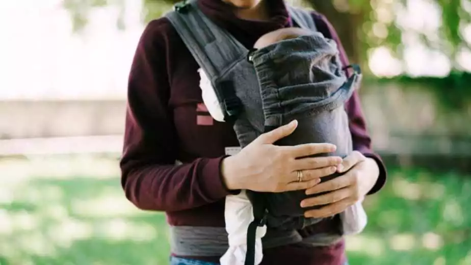 mom hands hug the baby in a sling