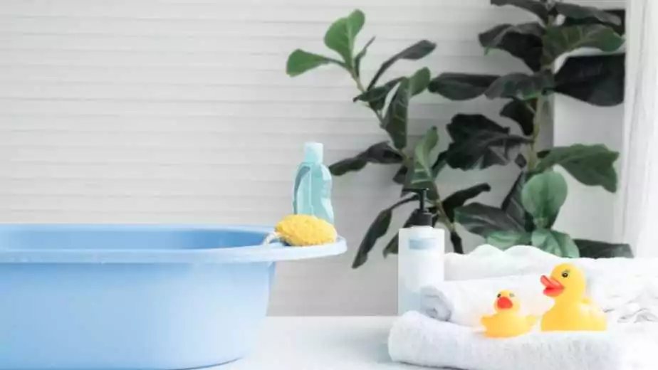 selective focus on sponge and liquid soap or shampoo bottle are place on blue bathtub