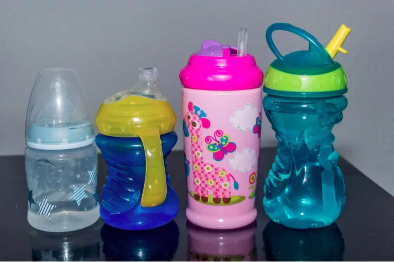 different types of baby water bottles on a black table with white background