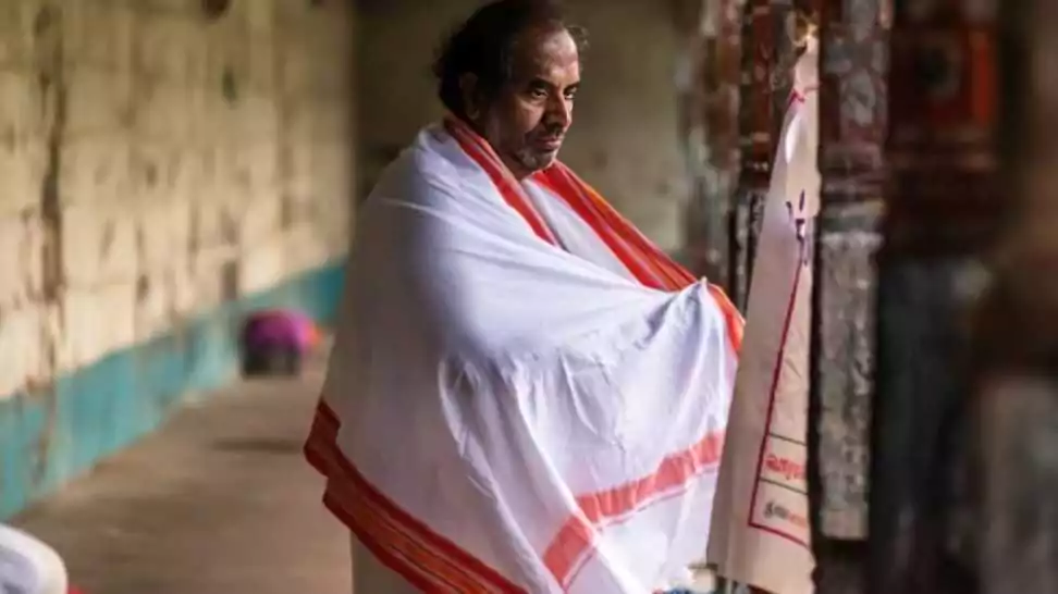 an indian pilgrim draped in a white stole known as angavastram inside the ancient hindu temple of vaitheeswaran koil