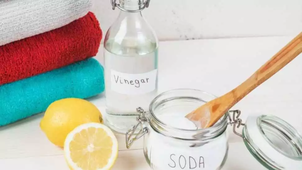 baking soda in jar with a wooden spoon on top along with vinegar