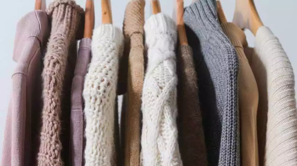row of multi coloured turtleneck knitwear sweater warm cloth on hangers