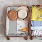 woman packing suitcase at home top view travel concept