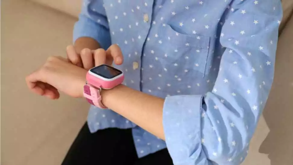girl using stylish smart watch on sofa