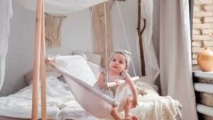 adorable baby girl lying in a linen handmade swing