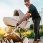 a young father lays out a stroller before walking with the baby