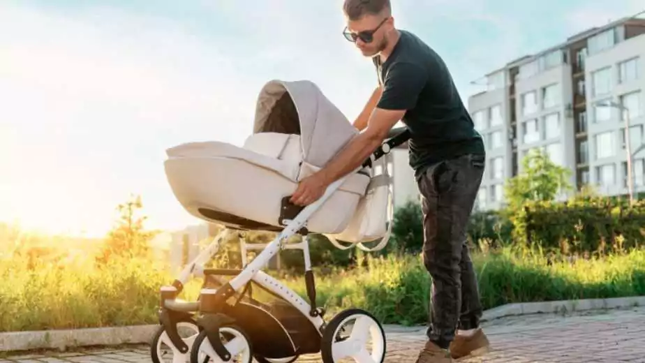 a young father lays out a stroller before walking with the baby