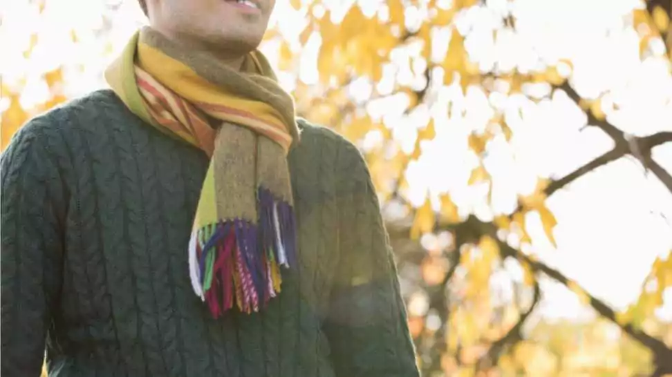 midsection of man wearing sweater and muffler in park during autumn