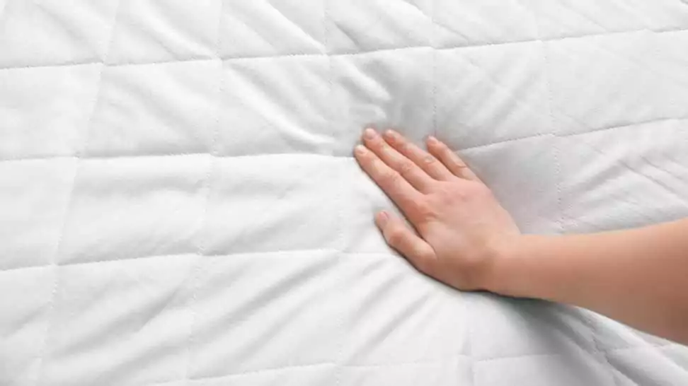 female hand on soft crib mattress