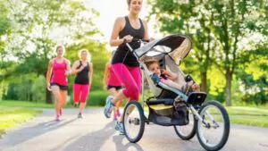 active mother jogging with her baby in jogging stroller