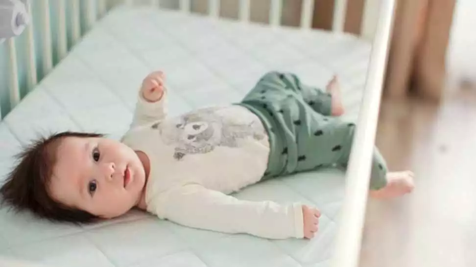cute baby boy lying in his crib