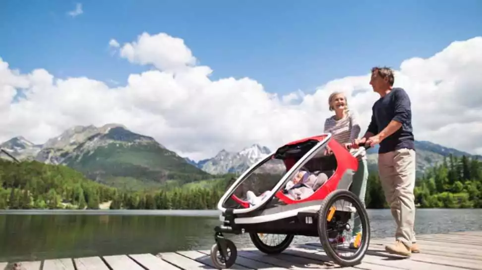 senior couple with grandchildren in jogging stroller