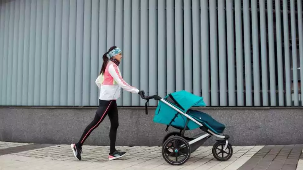 mom training with a stroller in the city on a cold autumn day