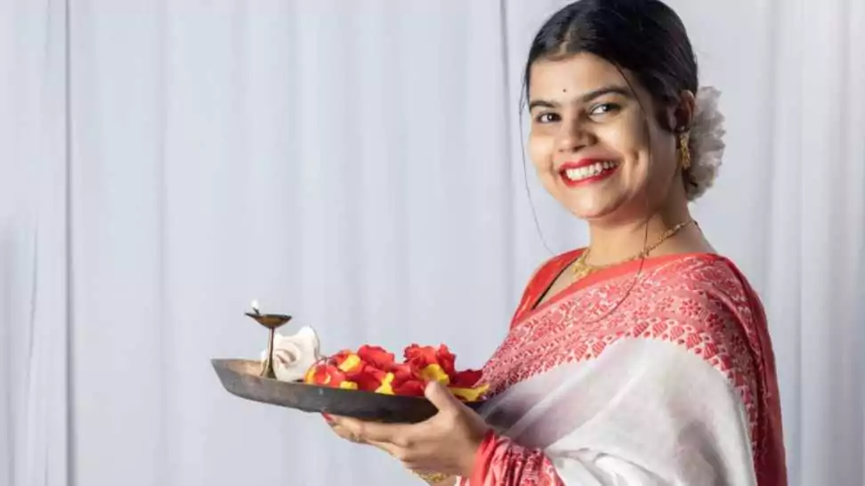 beautiful indian woman in bengali saree holding puja thali