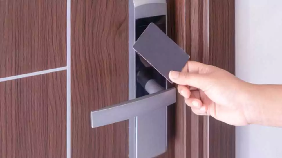 hand using electronic smart contactless key card for unlock door in hotel or house