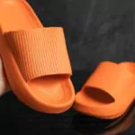 orange flip flops on dark black background