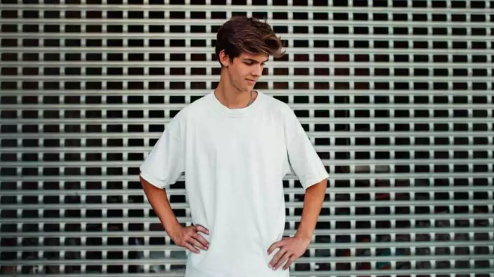 young handsome hipster guy wearing white blank oversized t shirt