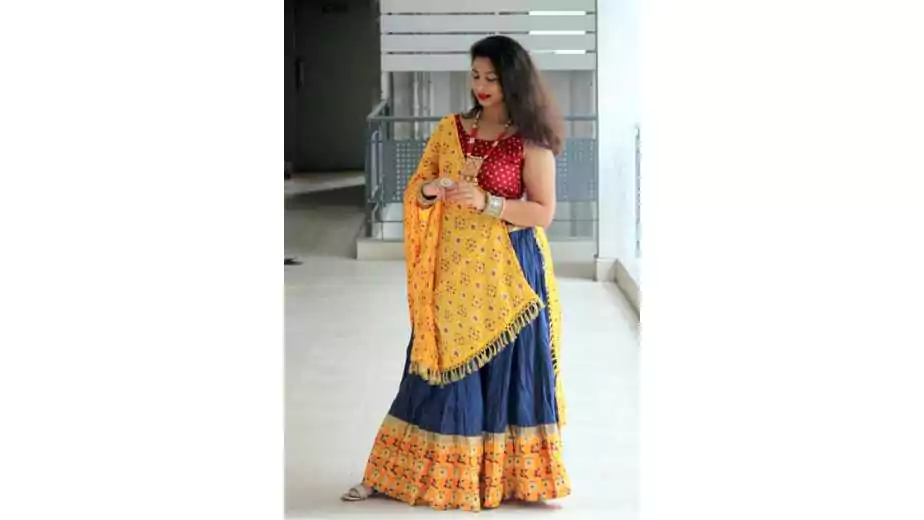 woman dressed up in yellow blue and red chaniya choli for garba